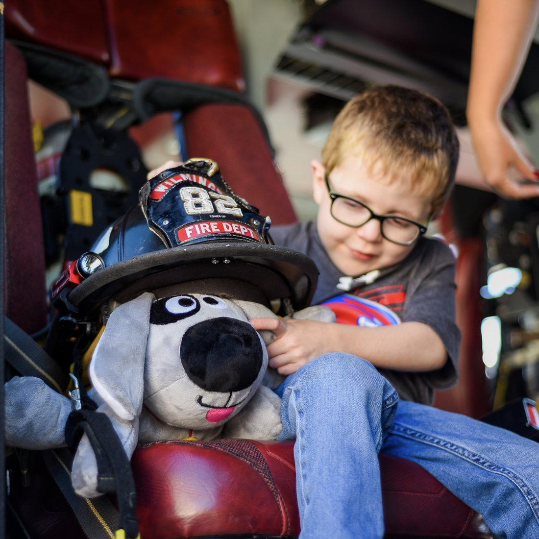 A child comforted by Trouble the Dog in a fire truck