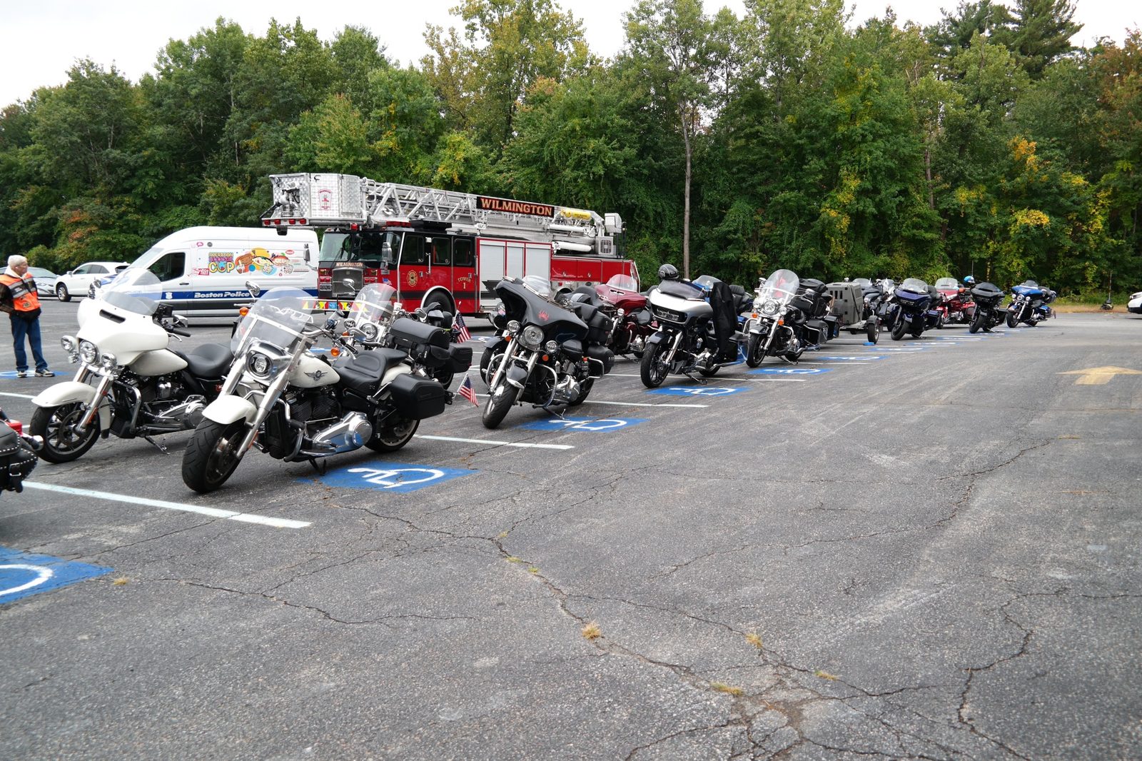 Motorcycles staged in the lot alongside fire and police vehicles before the ride